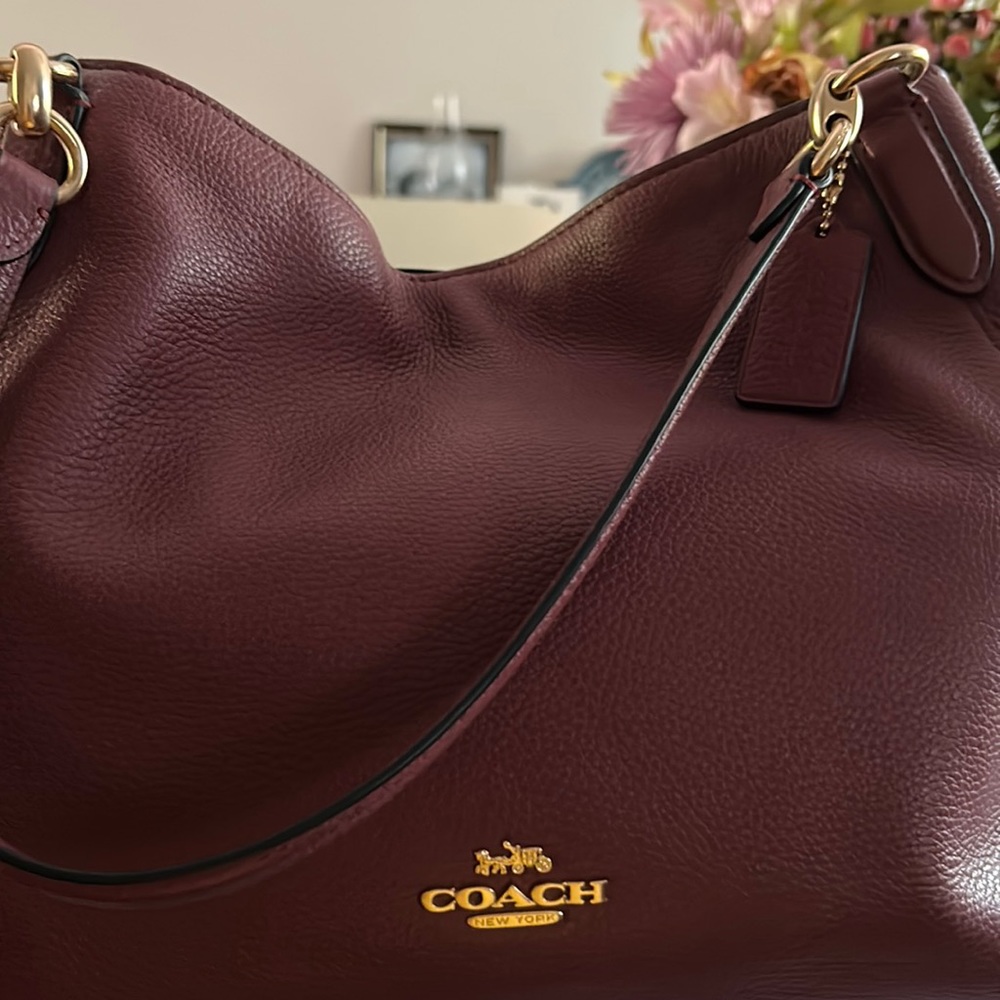 Double handle burgundy Coach leather bag.  Snap closure with zipper middle.